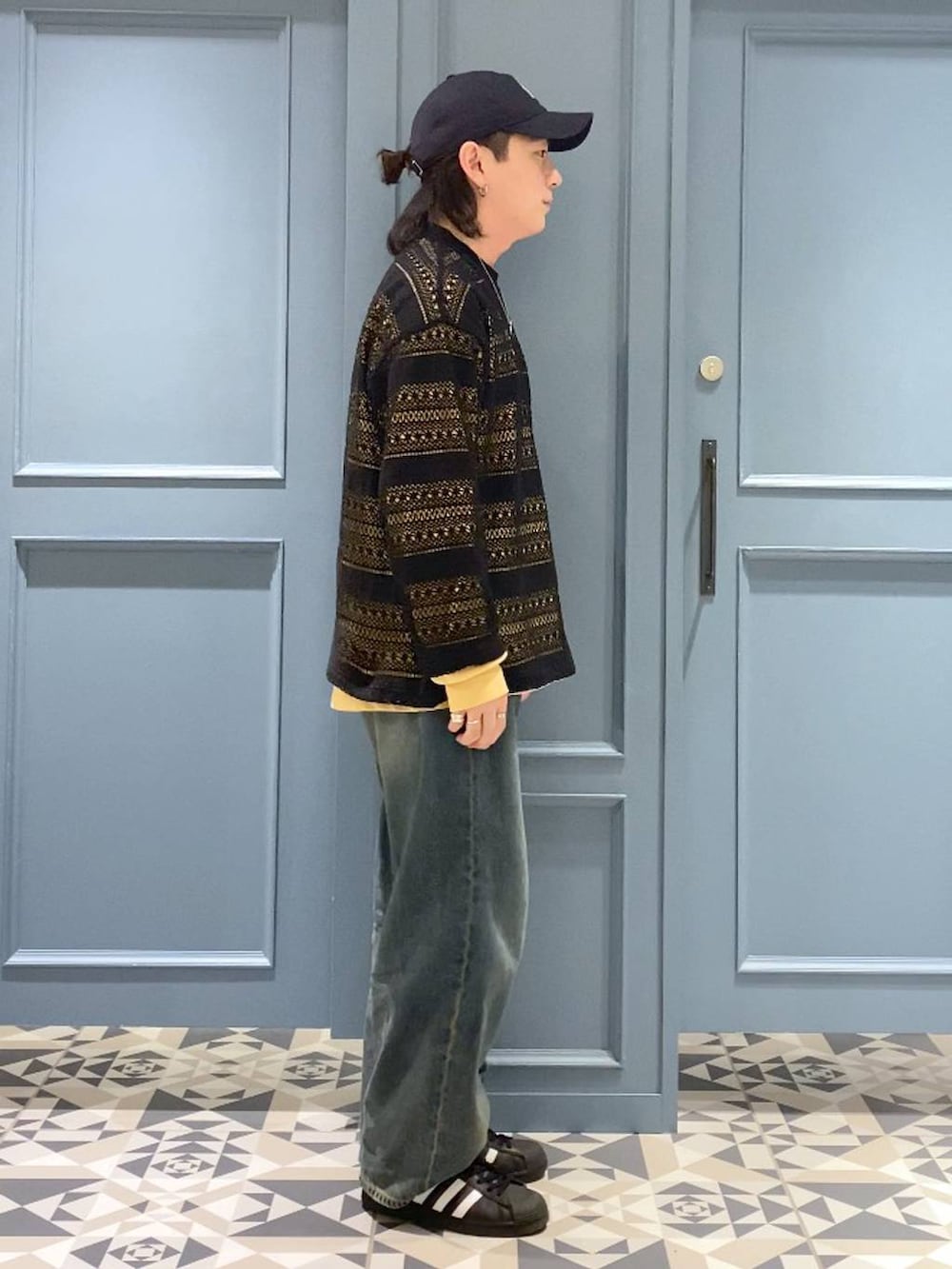 イエロー系のTシャツ/カットソー、ブルー系のデニムパンツ、ブラック系のTシャツ/カットソーを着用したメンズの春コーディネートの2枚目の写真