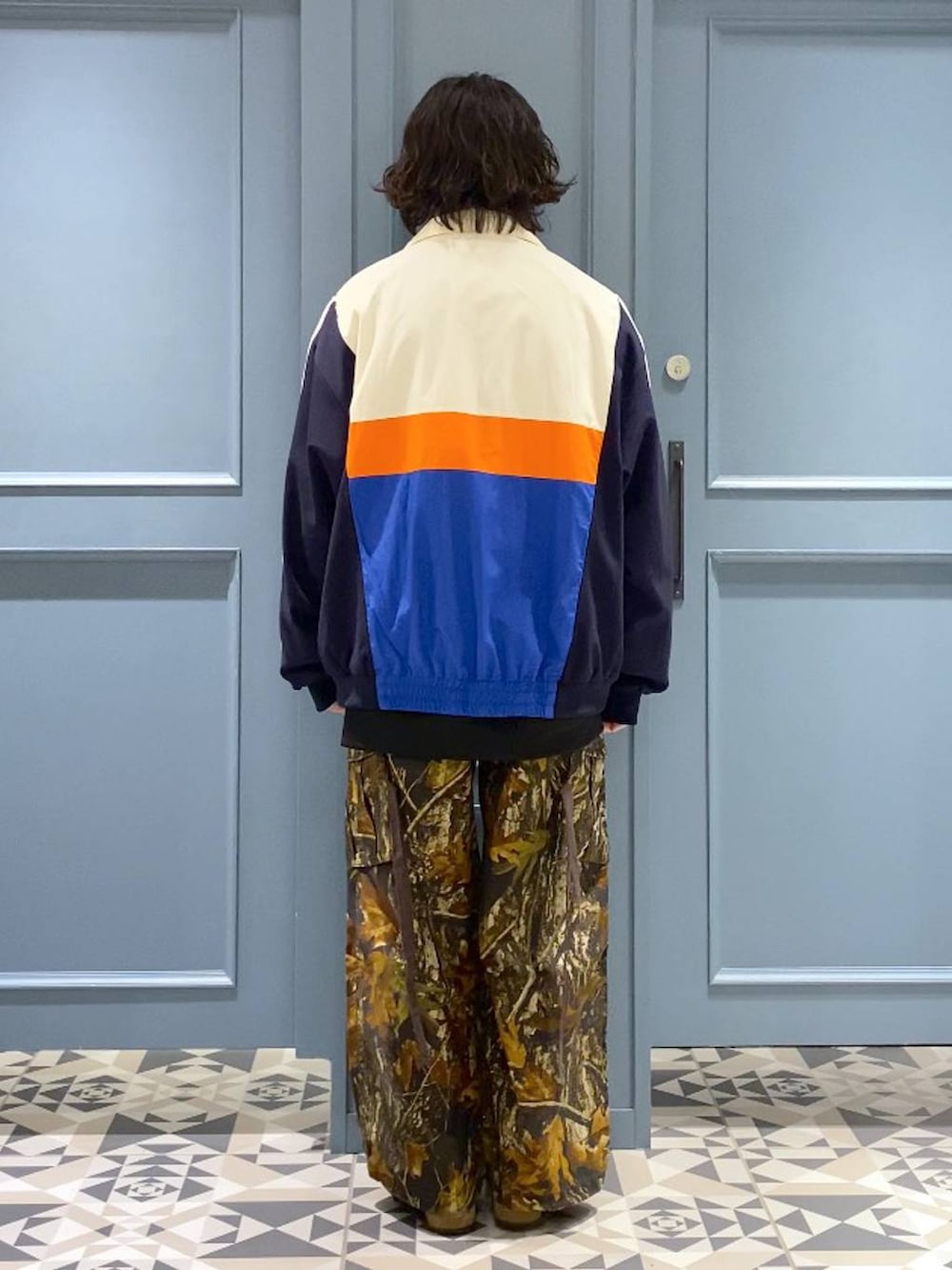 ブラック系のスウェット、ブラック系のTシャツ/カットソー、ホワイト系のブルゾンを着用したメンズの冬コーディネートの3枚目の写真