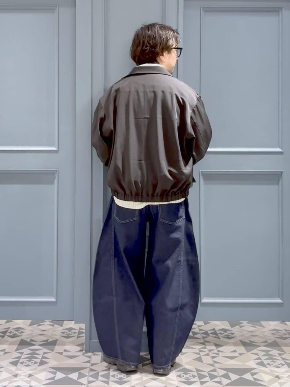 ブラック系のスニーカー、ブラック系のブルゾン、ホワイト系のシャツ/ブラウスを着用したメンズの春コーディネートの3枚目の写真