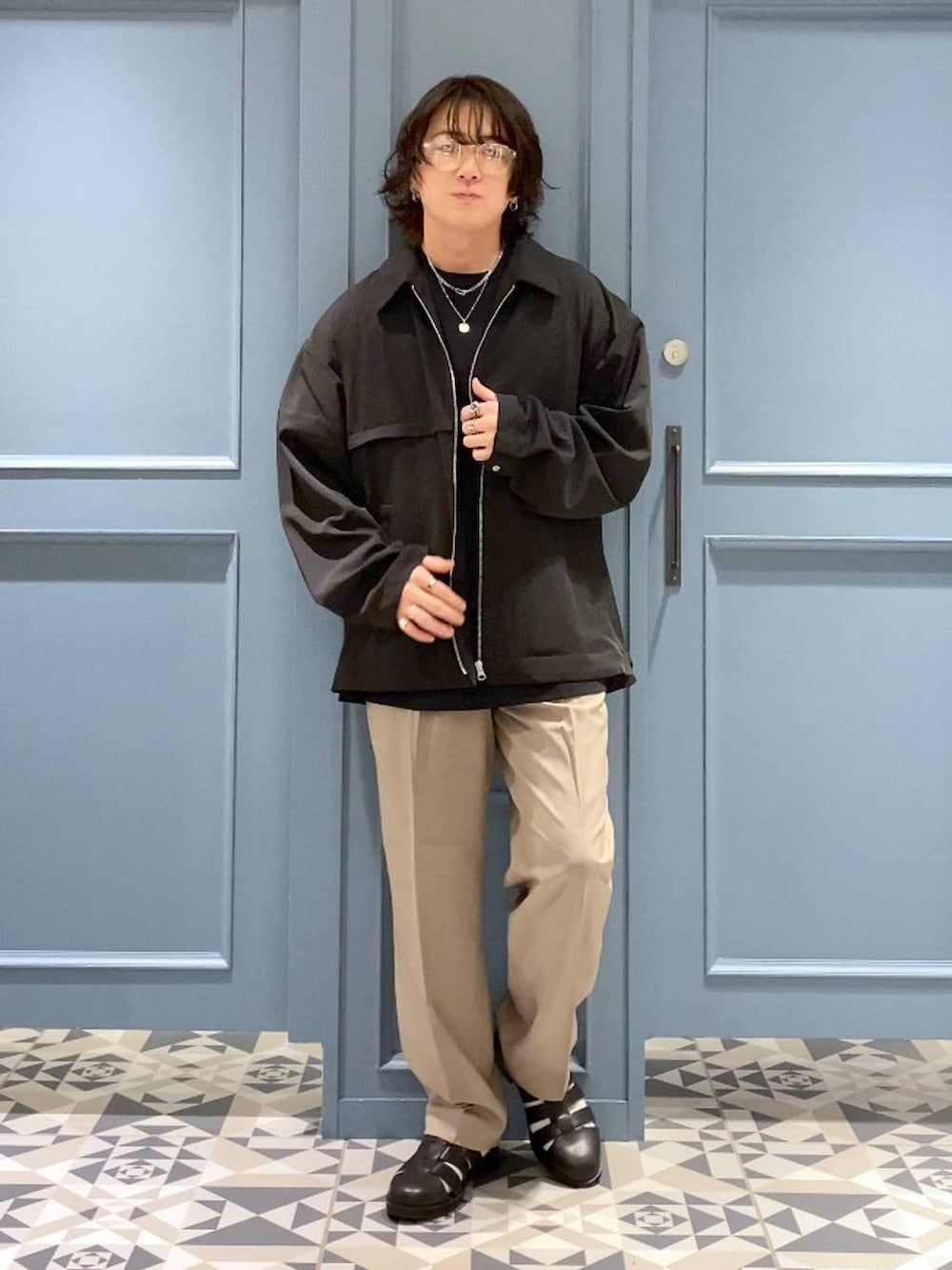 ブラック系のドレスシューズ、ブラック系のブルゾン、ブラック系のTシャツ/カットソーを着用したメンズの春コーディネートの4枚目の写真