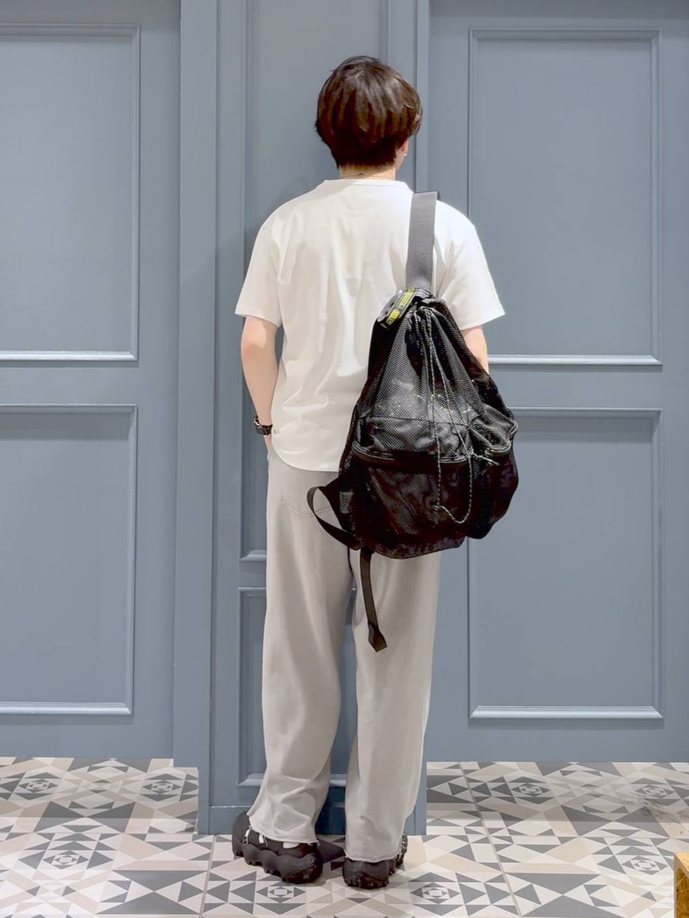 ブラック系のサンダル、ホワイト系のTシャツ/カットソー、ブラック系のバックパック/リュックを着用したメンズの夏コーディネートの3枚目の写真