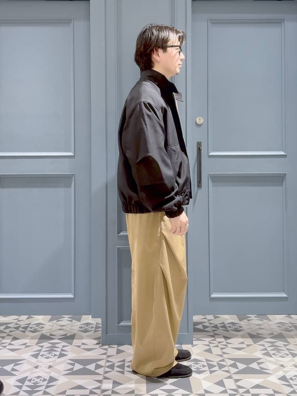 ブラック系のブルゾン、ブルー系のシャツ/ブラウスを着用したメンズの春コーディネートの2枚目の写真