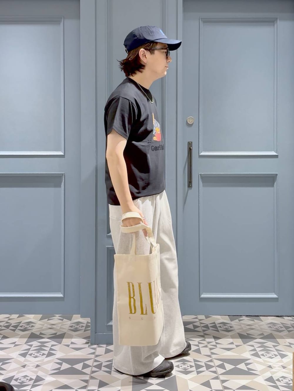 ブラック系のスニーカー、ブラック系のTシャツ/カットソー、グレー系のスウェットパンツを着用したメンズの夏コーディネートの2枚目の写真