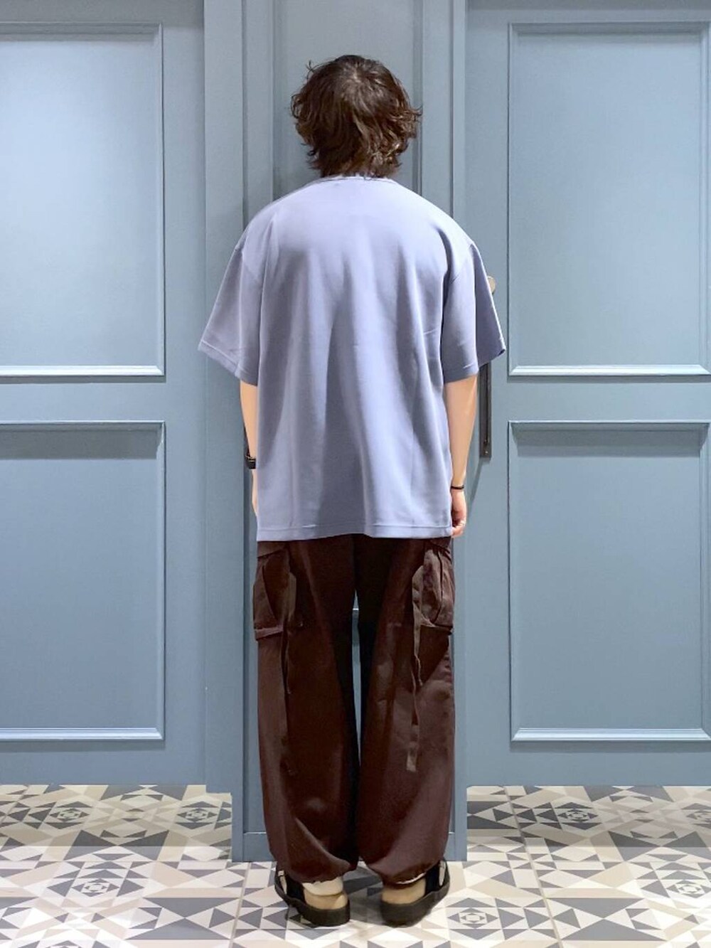 ブラウン系のカーゴパンツ、ブラック系のサンダル、ブルー系のTシャツ/カットソーを着用したメンズの夏コーディネートの3枚目の写真
