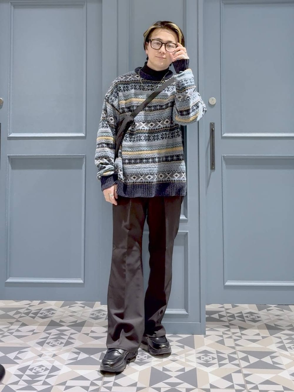 ブラウン系のスラックス、ブラック系のショルダーバッグ、ブラック系のローファーを着用したメンズの冬コーディネートの4枚目の写真