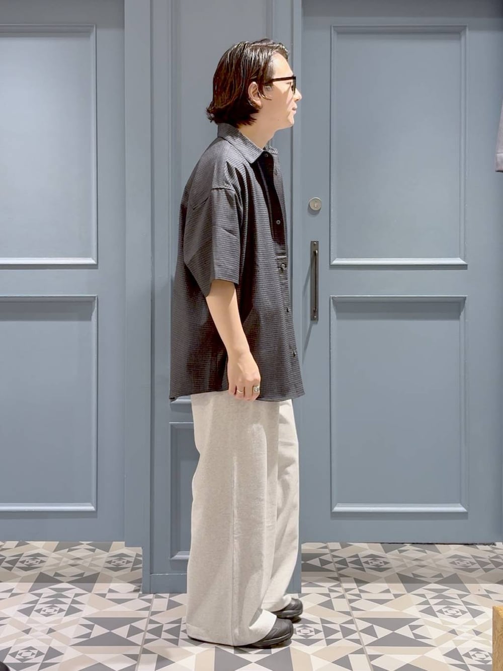 ブラック系のスニーカー、ホワイト系のTシャツ/カットソー、ブラック系のシャツ/ブラウスを着用したメンズの夏コーディネートの2枚目の写真