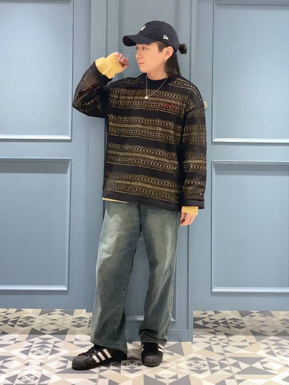 イエロー系のTシャツ/カットソー、ブルー系のデニムパンツ、ブラック系のTシャツ/カットソーを着用したメンズの春コーディネートの4枚目の写真