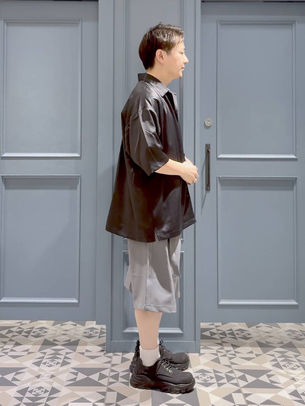 ブラック系のTシャツ/カットソー、ブラック系のシャツ/ブラウス、グレー系のスラックスを着用したメンズの夏コーディネートの2枚目の写真