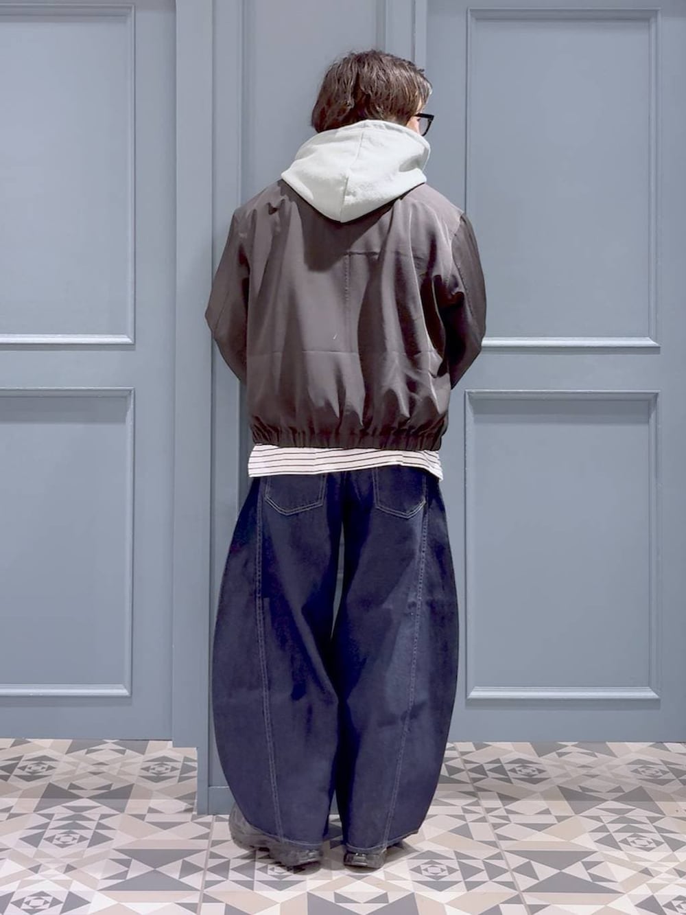 ブラック系のスニーカー、グリーン系のパーカー、ブラック系のブルゾンを着用したメンズの春コーディネートの3枚目の写真