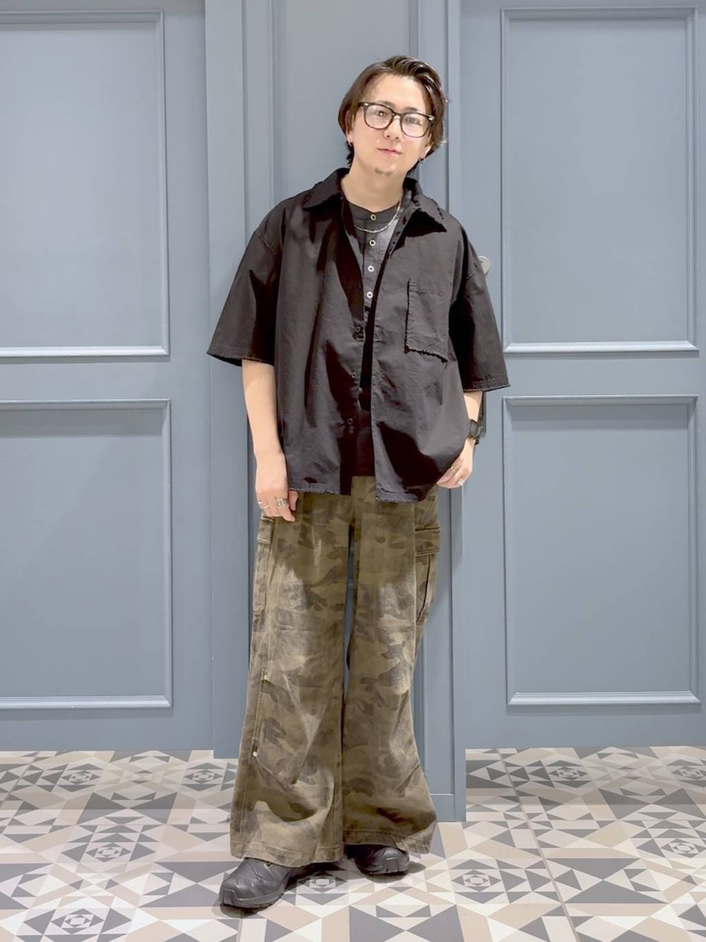 グリーン系のカーゴパンツ、ブラック系のシャツ/ブラウス、ブラック系のスニーカーを着用したメンズの夏コーディネートの4枚目の写真