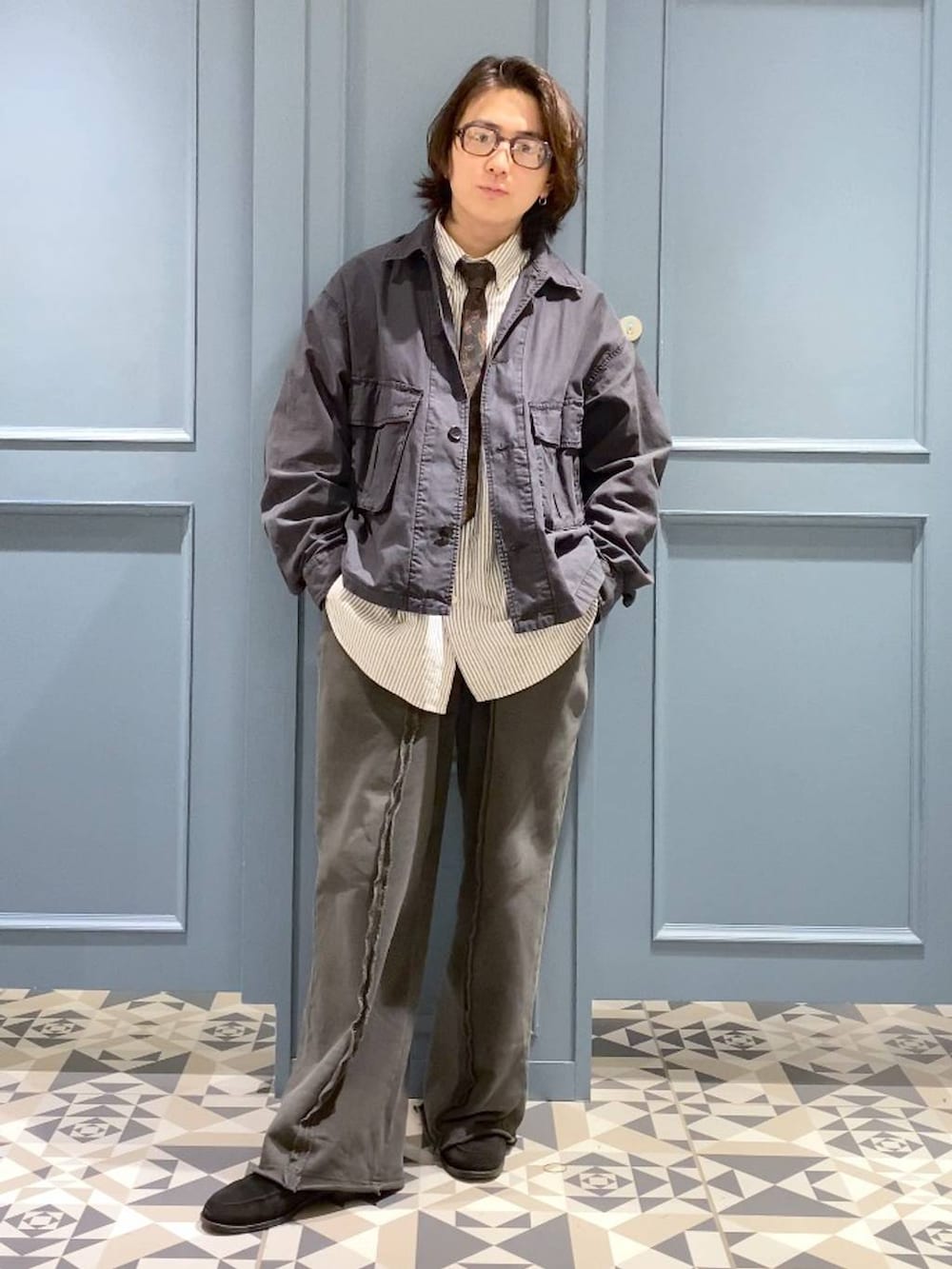 ホワイト系のネクタイ、グレー系のシャツ/ブラウス、ブラック系のミリタリージャケットを着用したメンズの冬コーディネートの4枚目の写真