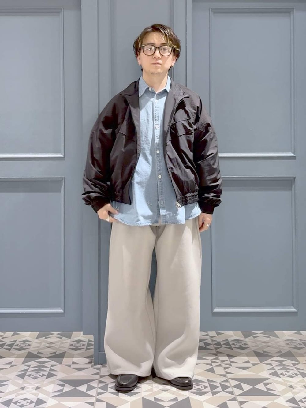 ブラック系のモカシン/デッキシューズ、ブラック系のナイロンジャケット、グレー系のその他パンツを着用したメンズの春コーディネートの4枚目の写真