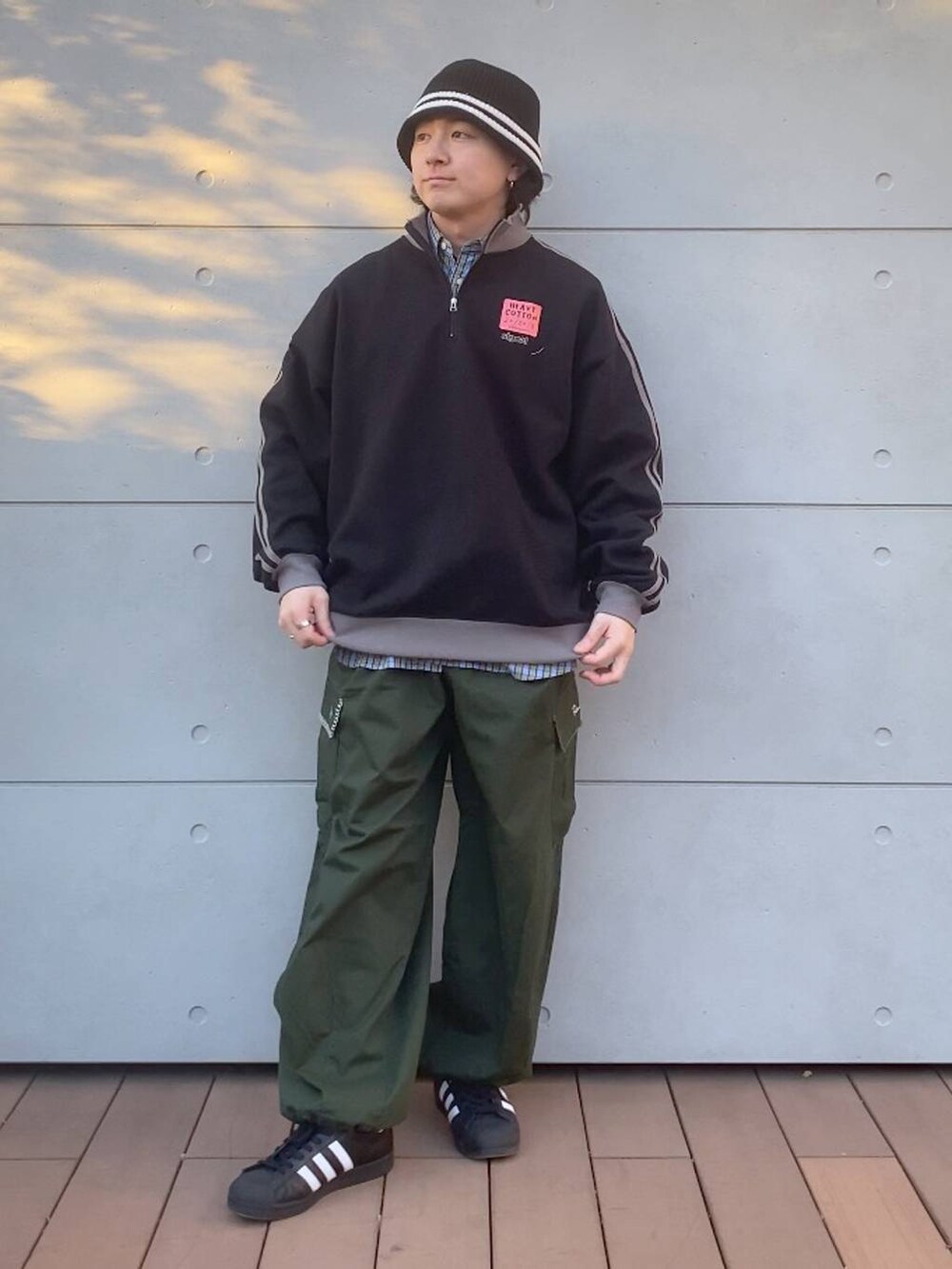 グリーン系のカーゴパンツ、ブラック系のスウェット、ブルー系のシャツ/ブラウスを着用したメンズの冬コーディネートの4枚目の写真