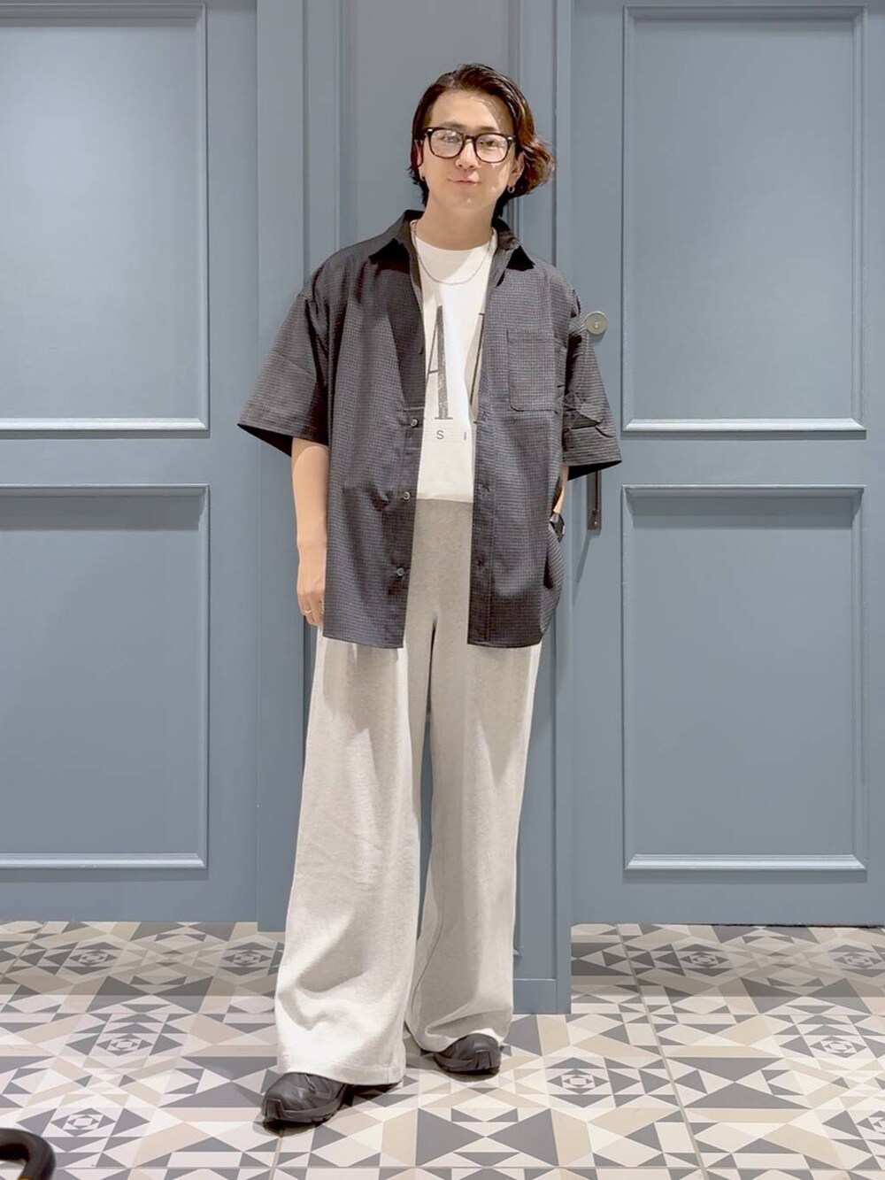 ブラック系のスニーカー、ホワイト系のTシャツ/カットソー、ブラック系のシャツ/ブラウスを着用したメンズの夏コーディネートの4枚目の写真