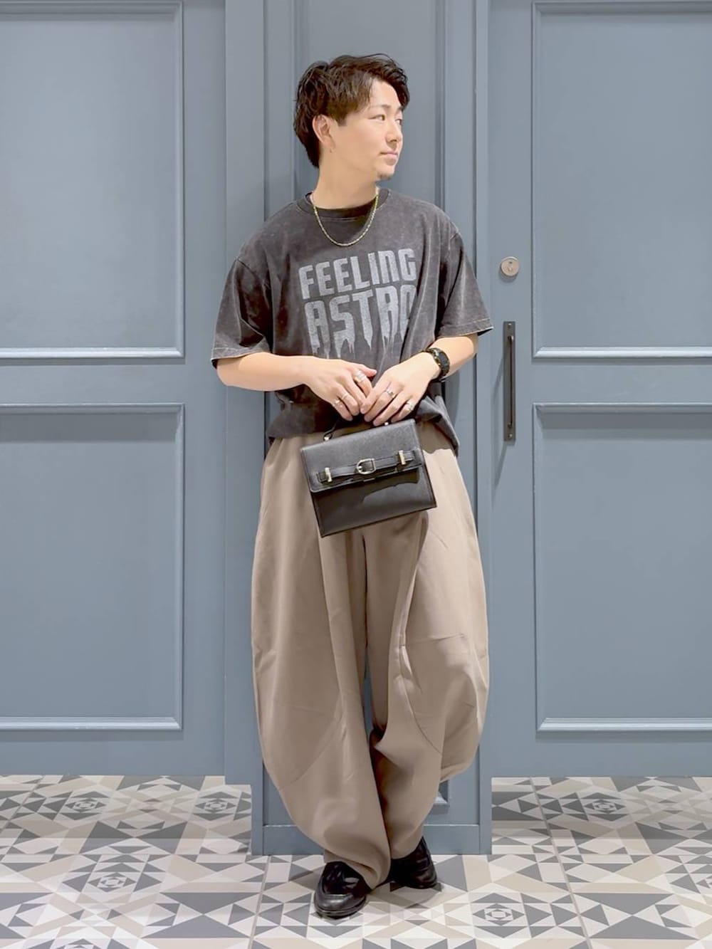 ベージュ系のスラックス、グレー系のTシャツ/カットソー、ブラック系のローファーを着用したメンズの秋コーディネートの4枚目の写真
