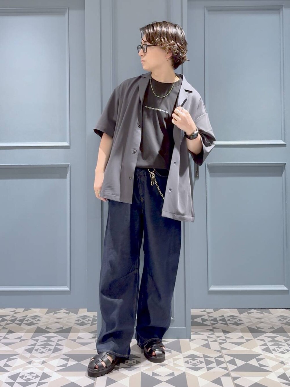 グレー系のシャツ/ブラウス、ブラック系のサンダル、ブルー系のデニムパンツを着用したメンズの夏コーディネートの4枚目の写真