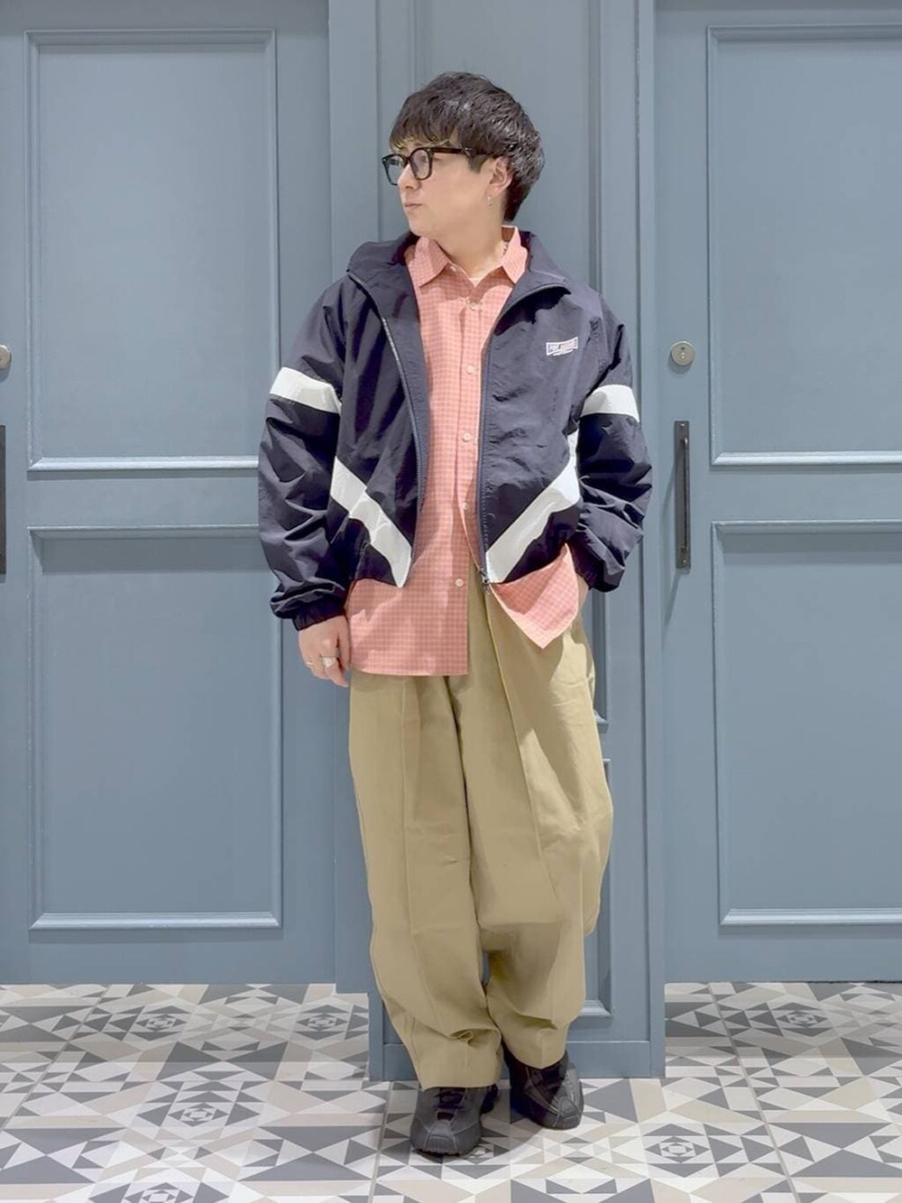 ピンク系のシャツ/ブラウス、ブルー系のブルゾン、ベージュ系のチノパンツを着用したメンズの冬コーディネートの4枚目の写真