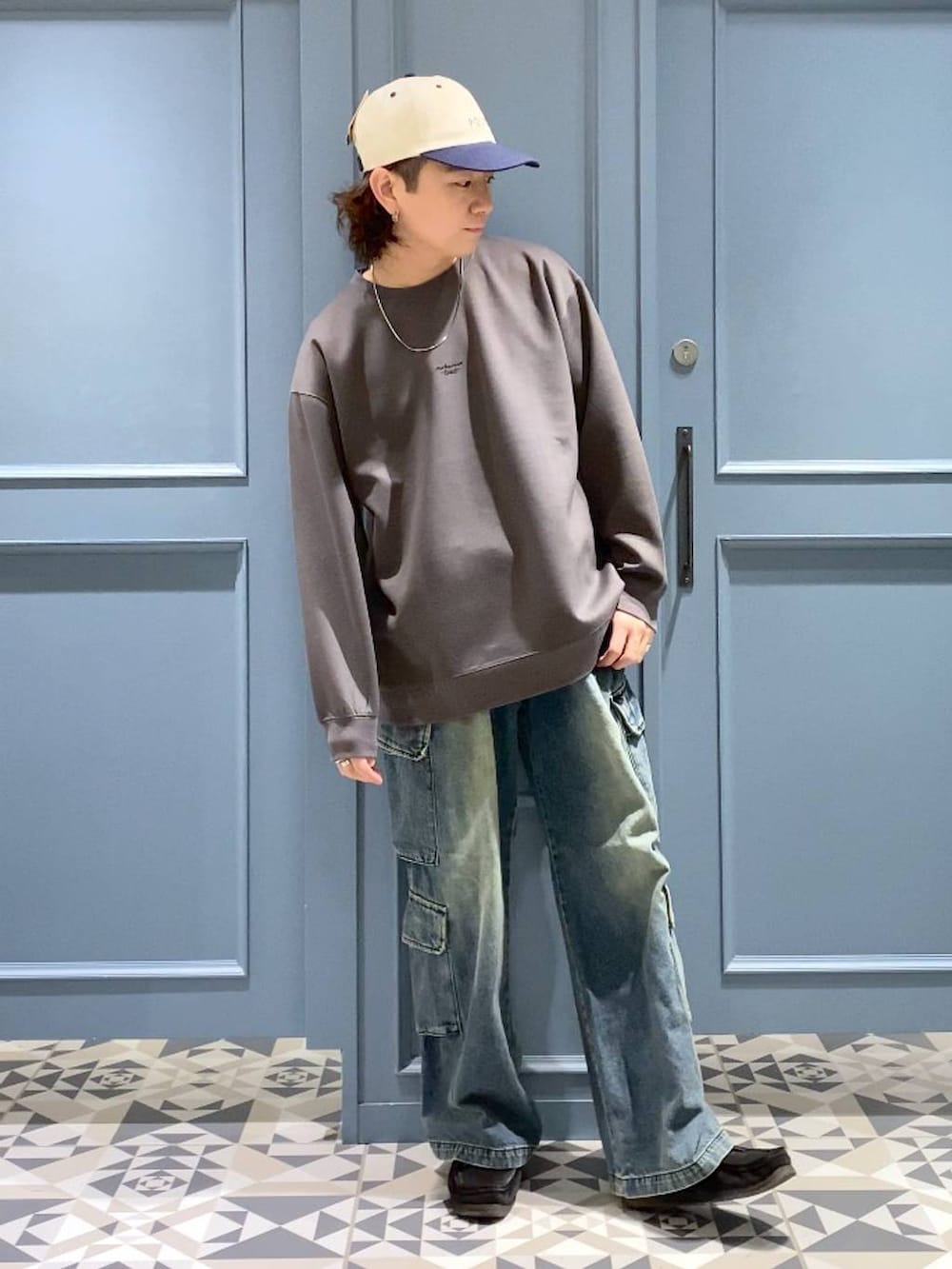 ブルー系のデニムパンツ、ブラック系のモカシン/デッキシューズ、グレー系のスウェットを着用したメンズの冬コーディネートの4枚目の写真