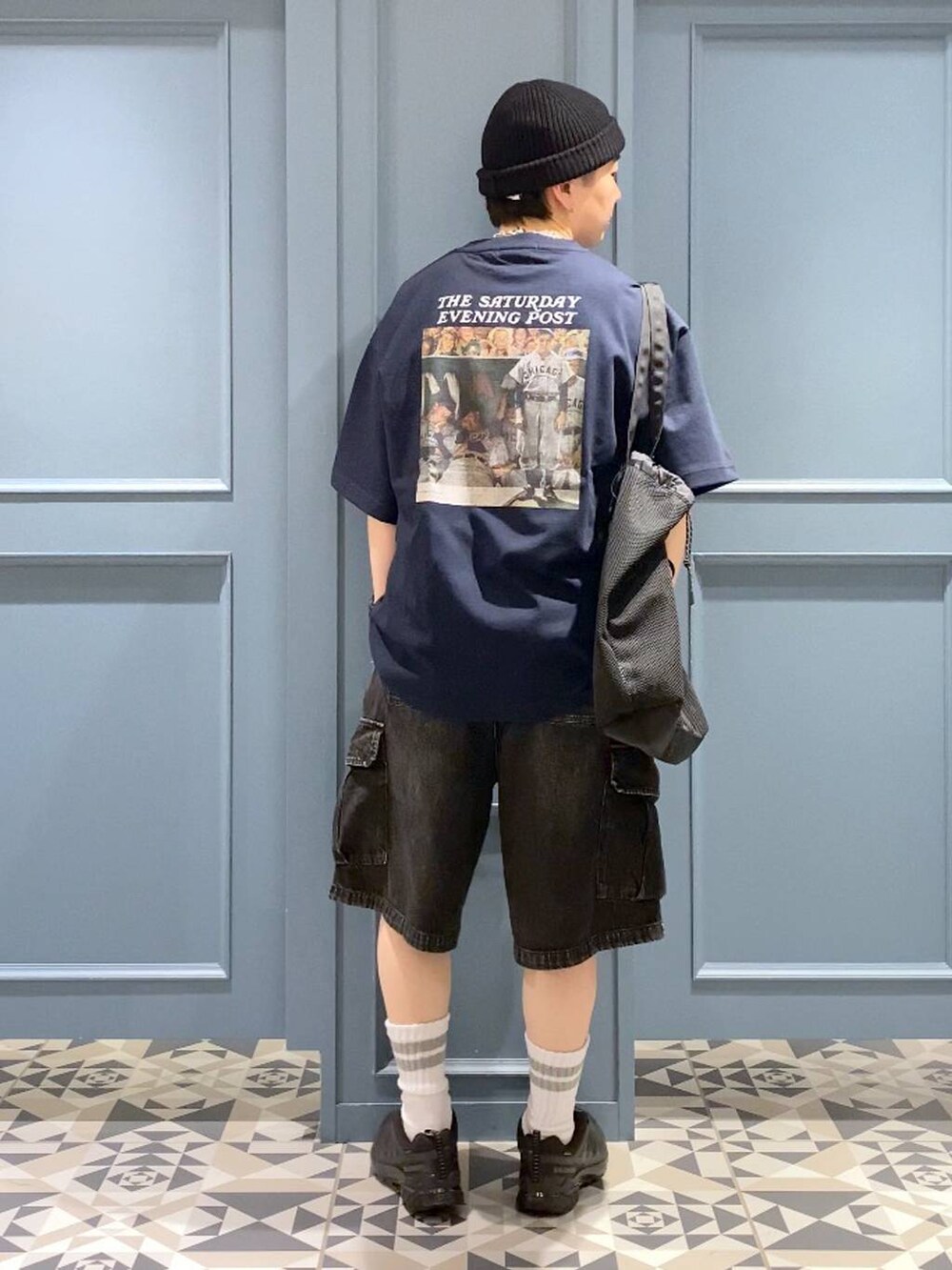 ブラック系のスニーカー、グレー系のカーゴパンツ、ブラック系のトートバッグを着用したメンズの春コーディネートの3枚目の写真