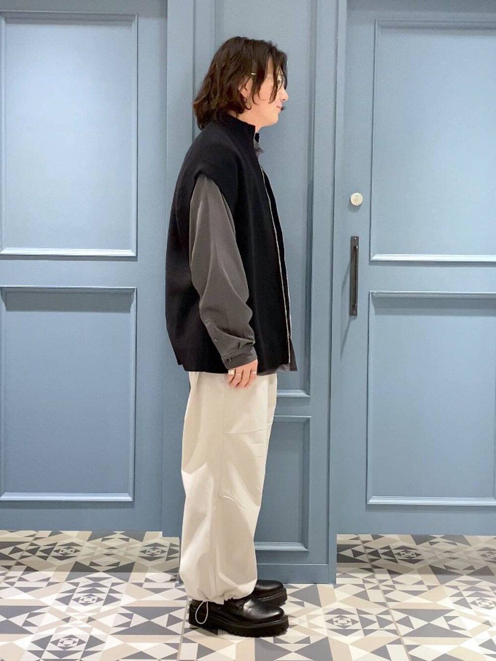 ブラック系のベスト、ブラック系のドレスシューズ、グレー系のシャツ/ブラウスを着用したメンズの春コーディネートの2枚目の写真