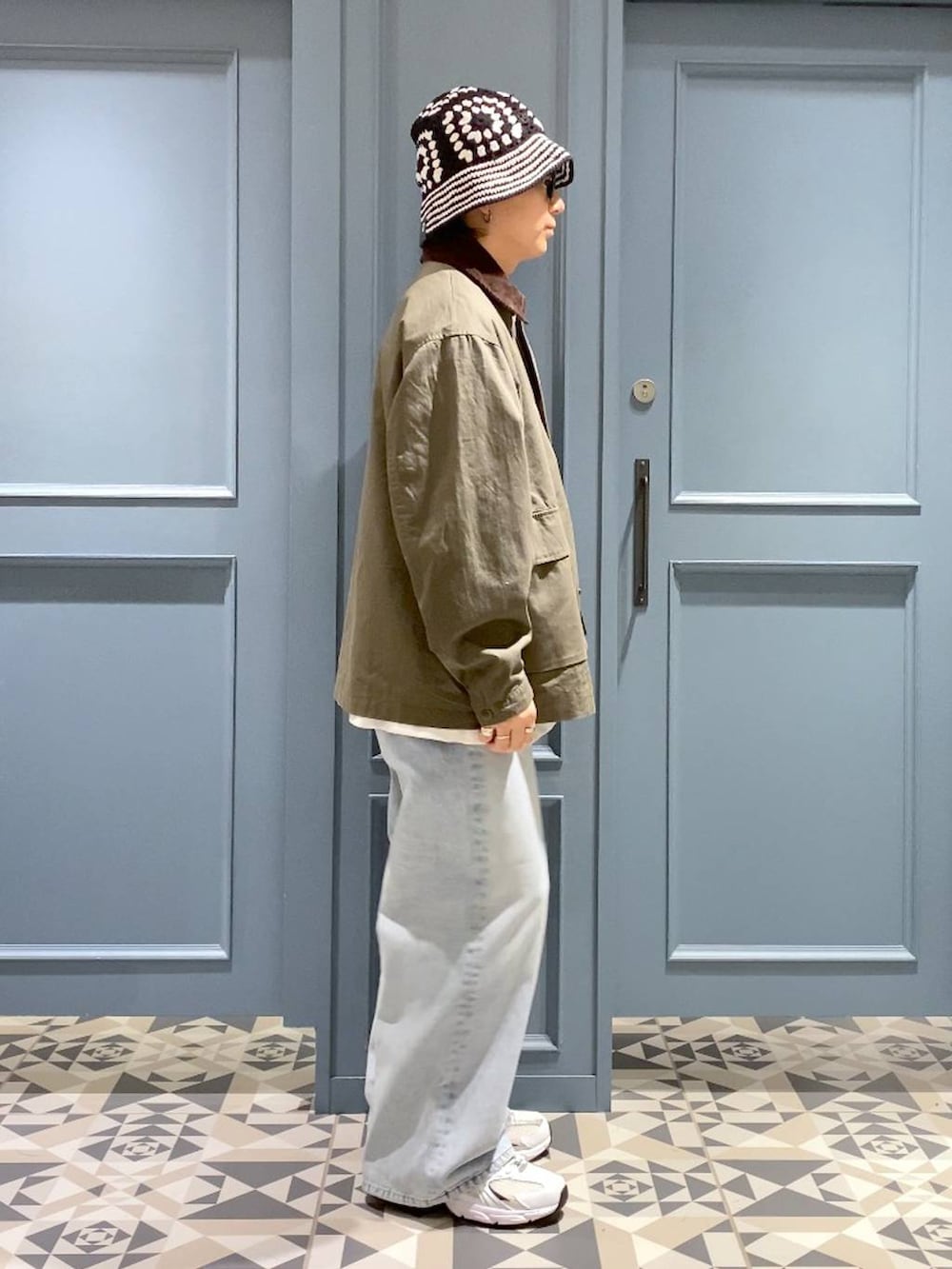 ホワイト系のスニーカー、ブルー系のデニムパンツ、ホワイト系のTシャツ/カットソーを着用したメンズの秋コーディネートの2枚目の写真