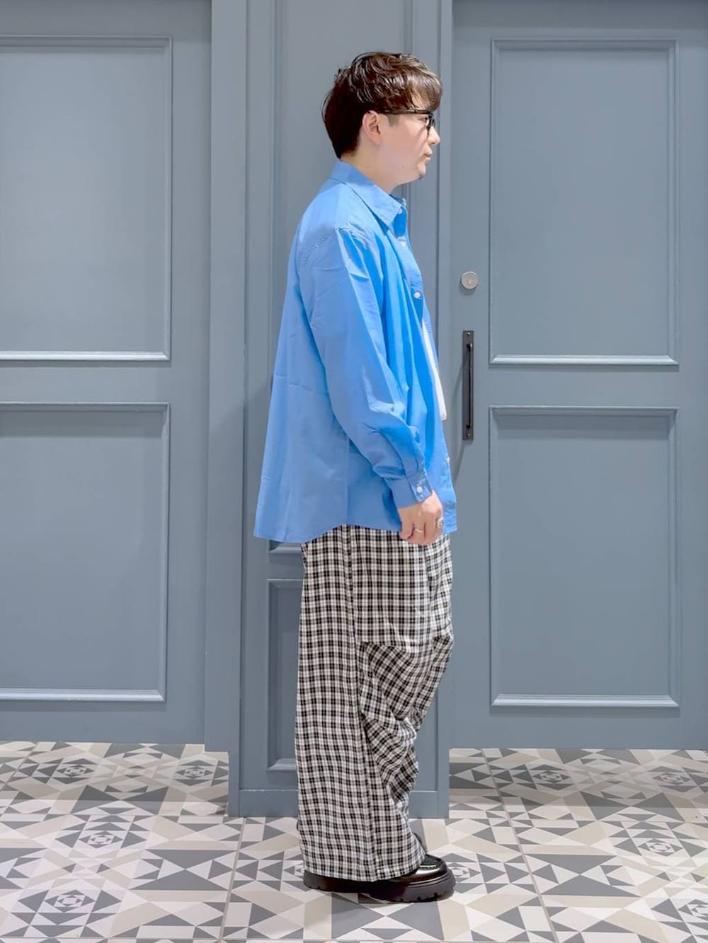 ブラック系のドレスシューズ、ブルー系のシャツ/ブラウス、ブラック系のカーゴパンツを着用したメンズの春コーディネートの2枚目の写真