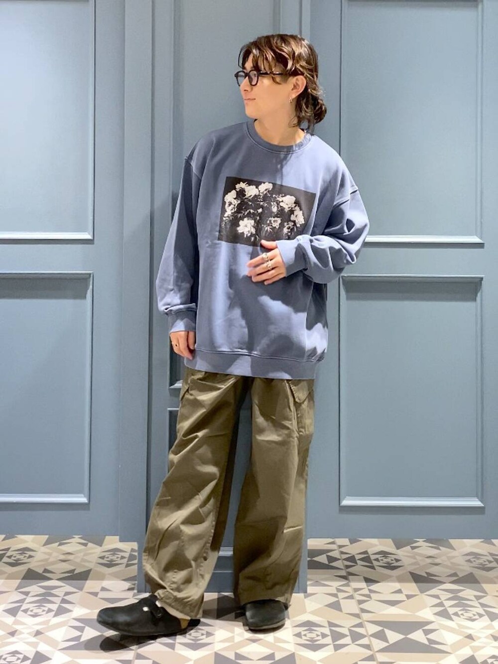 グリーン系のカーゴパンツ、ブルー系のスウェット、ブラック系のサングラスを着用したメンズの冬コーディネートの4枚目の写真