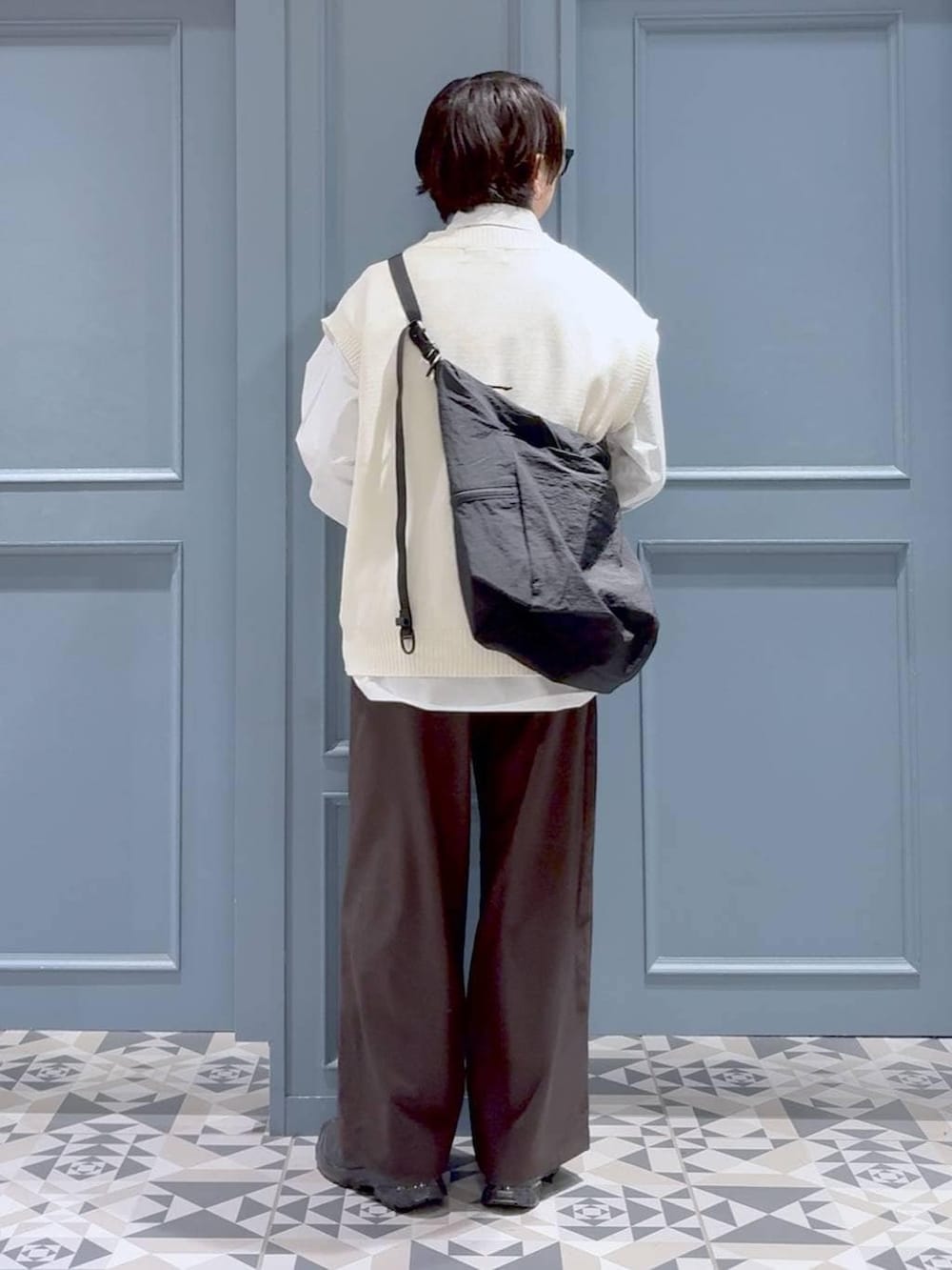 ブラック系のスニーカー、その他のネクタイ、ブラック系のショルダーバッグを着用したメンズの冬コーディネートの3枚目の写真