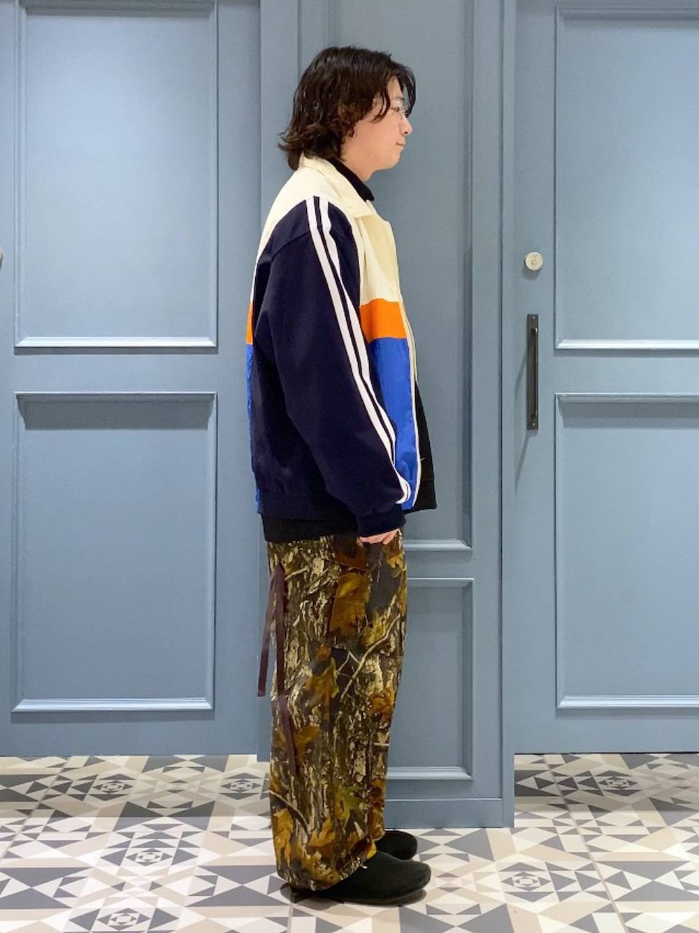 ブラック系のスウェット、ブラック系のTシャツ/カットソー、ホワイト系のブルゾンを着用したメンズの冬コーディネートの2枚目の写真