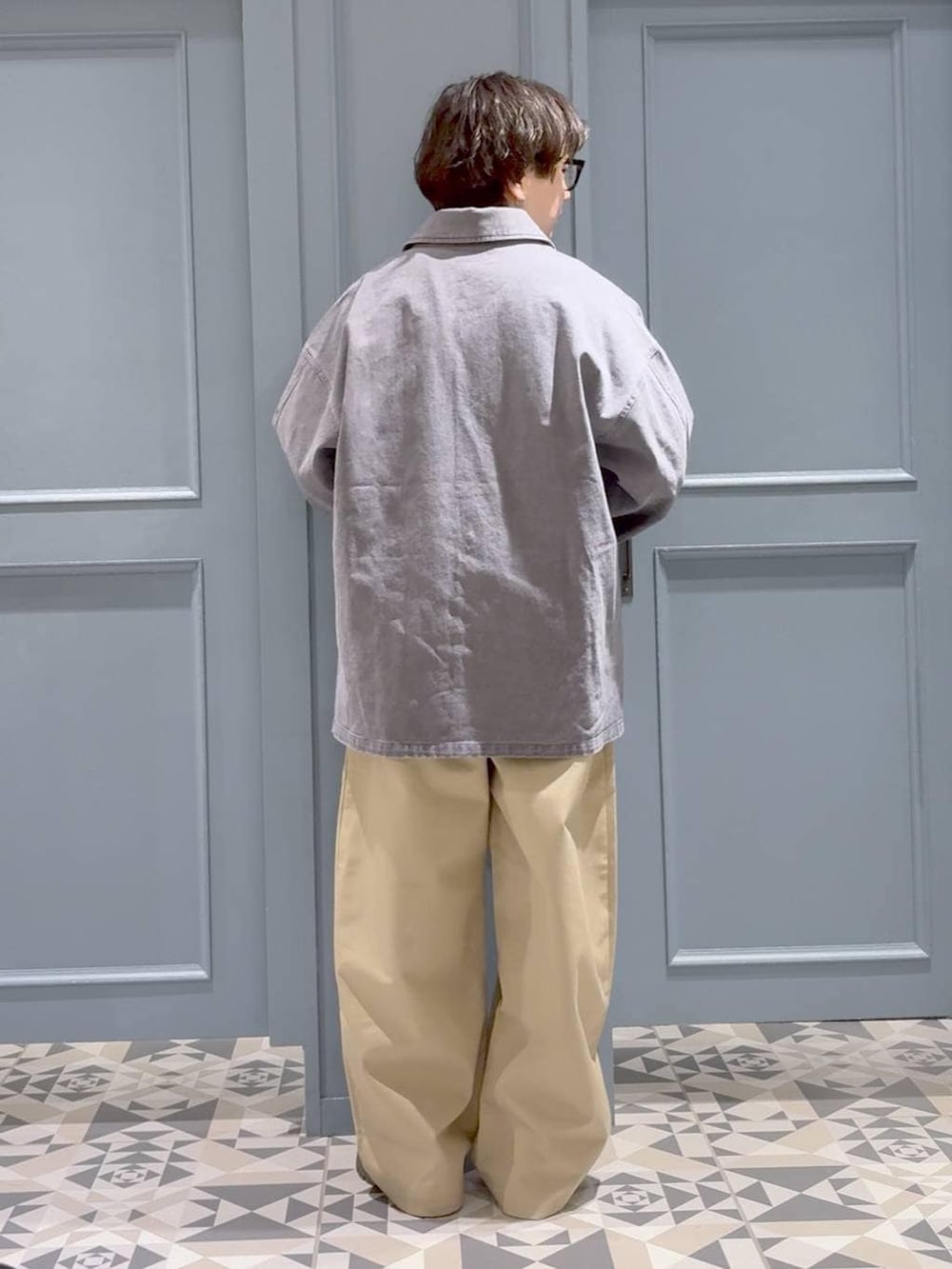 ブラック系のドレスシューズ、ベージュ系のチノパンツ、グレー系のミリタリージャケットを着用したメンズの春コーディネートの3枚目の写真