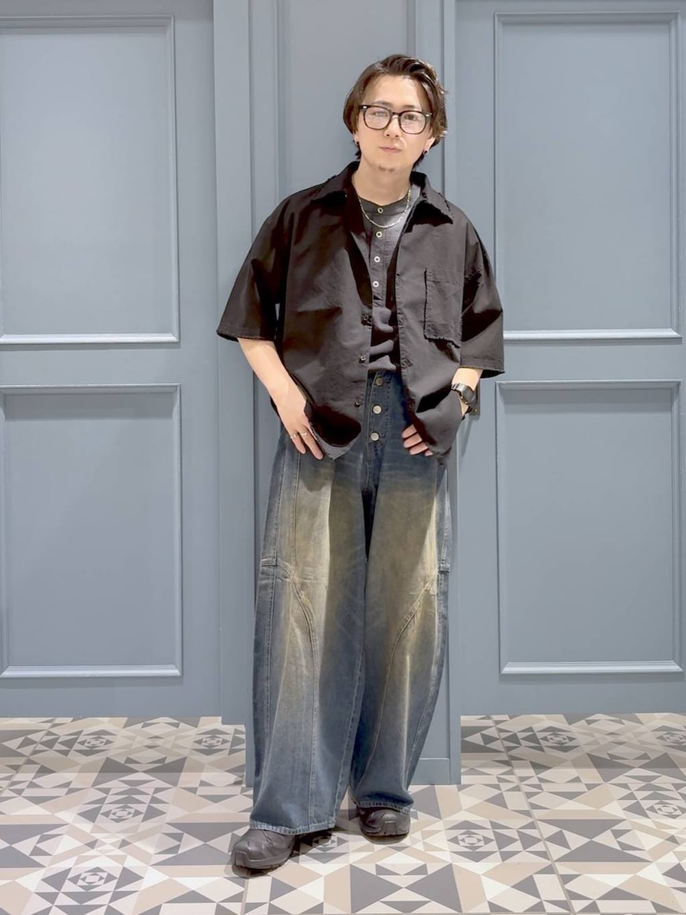 ブラック系のシャツ/ブラウス、ブラック系のスニーカー、ブルー系のデニムパンツを着用したメンズの夏コーディネートの4枚目の写真
