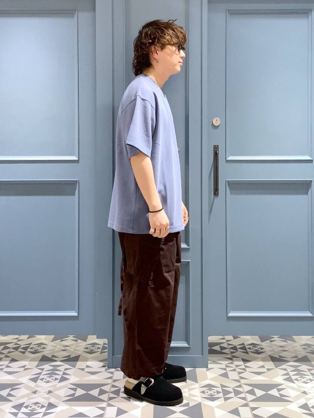 ブラウン系のカーゴパンツ、ブラック系のサンダル、ブルー系のTシャツ/カットソーを着用したメンズの夏コーディネートの2枚目の写真