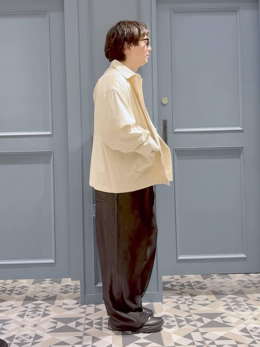 ブラック系のサンダル、ブラック系のサロペット/オーバーオール、ホワイト系のデニムジャケットを着用したメンズの春コーディネートの2枚目の写真