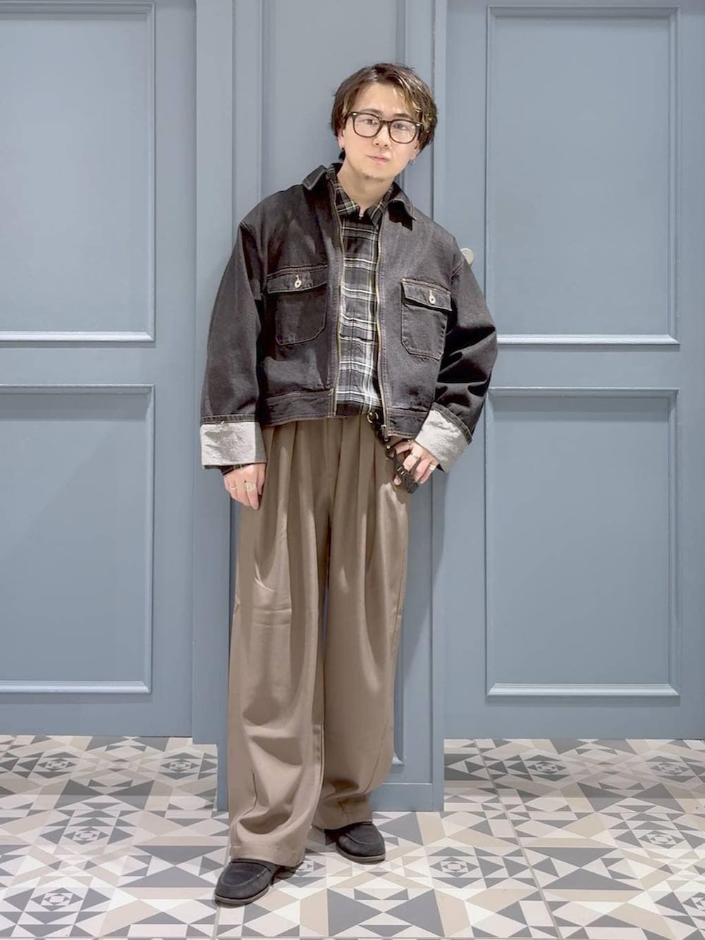 ブラック系のデニムジャケット、イエロー系のスラックス、ブラック系のブルゾンを着用したメンズの春コーディネートの4枚目の写真