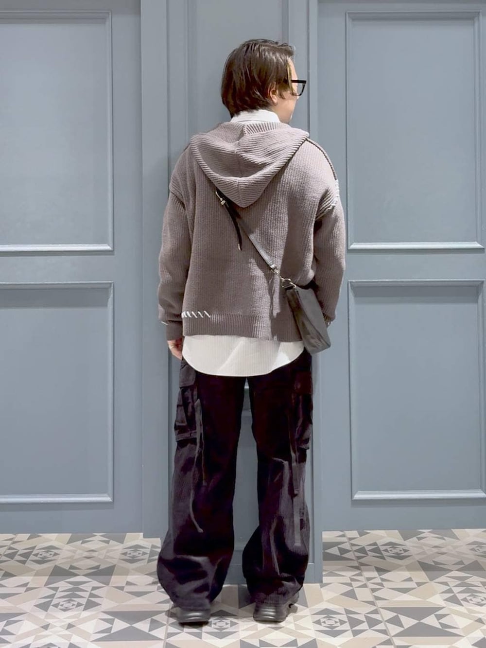 ブラック系のカーゴパンツ、その他のショルダーバッグ、ブラック系のローファーを着用したメンズの冬コーディネートの3枚目の写真