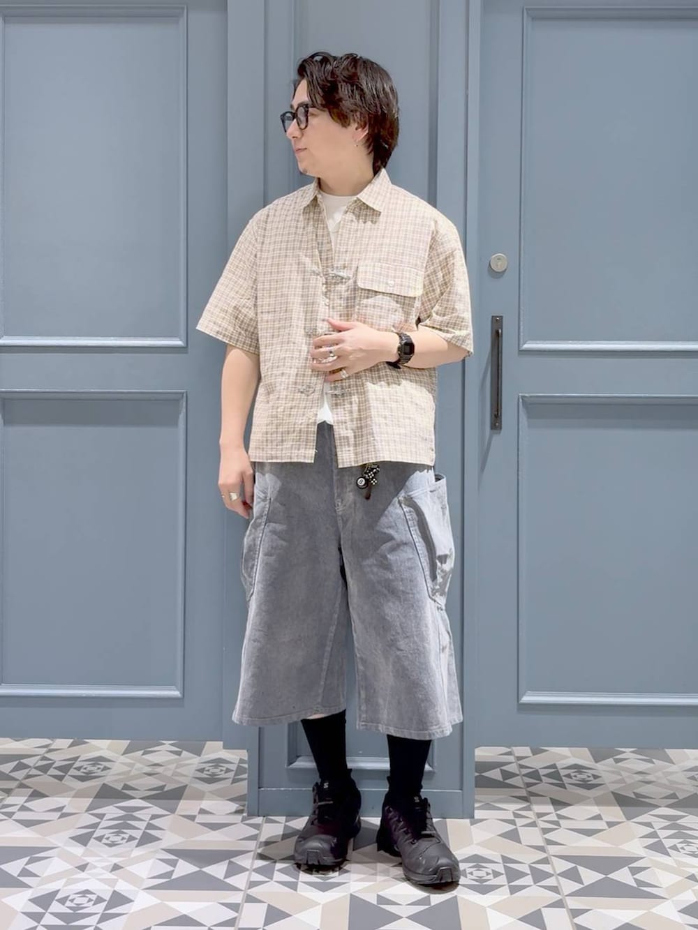 ブラック系のスニーカー、ホワイト系のTシャツ/カットソー、グレー系のデニムパンツを着用したメンズの夏コーディネートの4枚目の写真