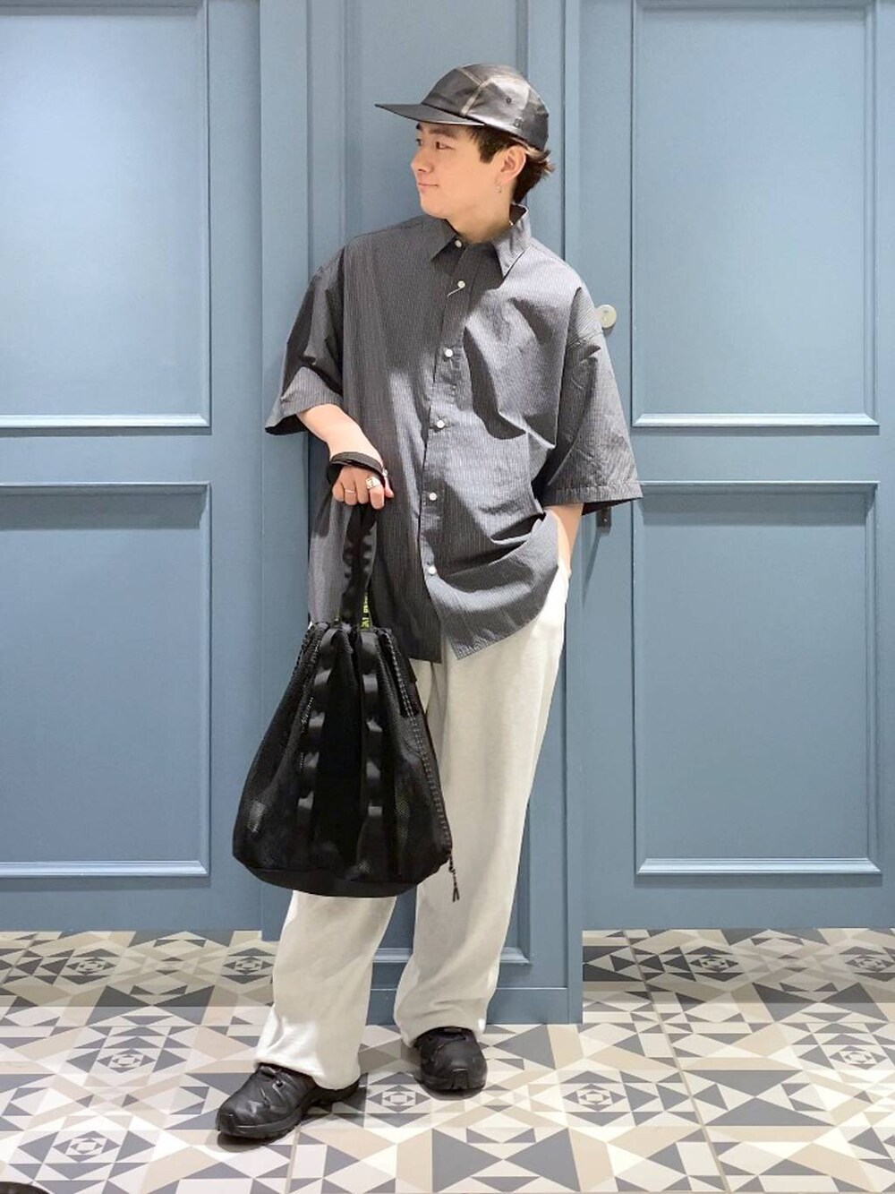 ブラック系のスニーカー、グレー系のシャツ/ブラウス、ブラック系のトートバッグを着用したメンズの春コーディネートの4枚目の写真