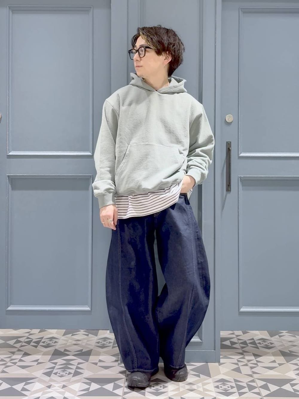 ブラック系のスニーカー、グリーン系のパーカー、ホワイト系のTシャツ/カットソーを着用したメンズの春コーディネートの4枚目の写真