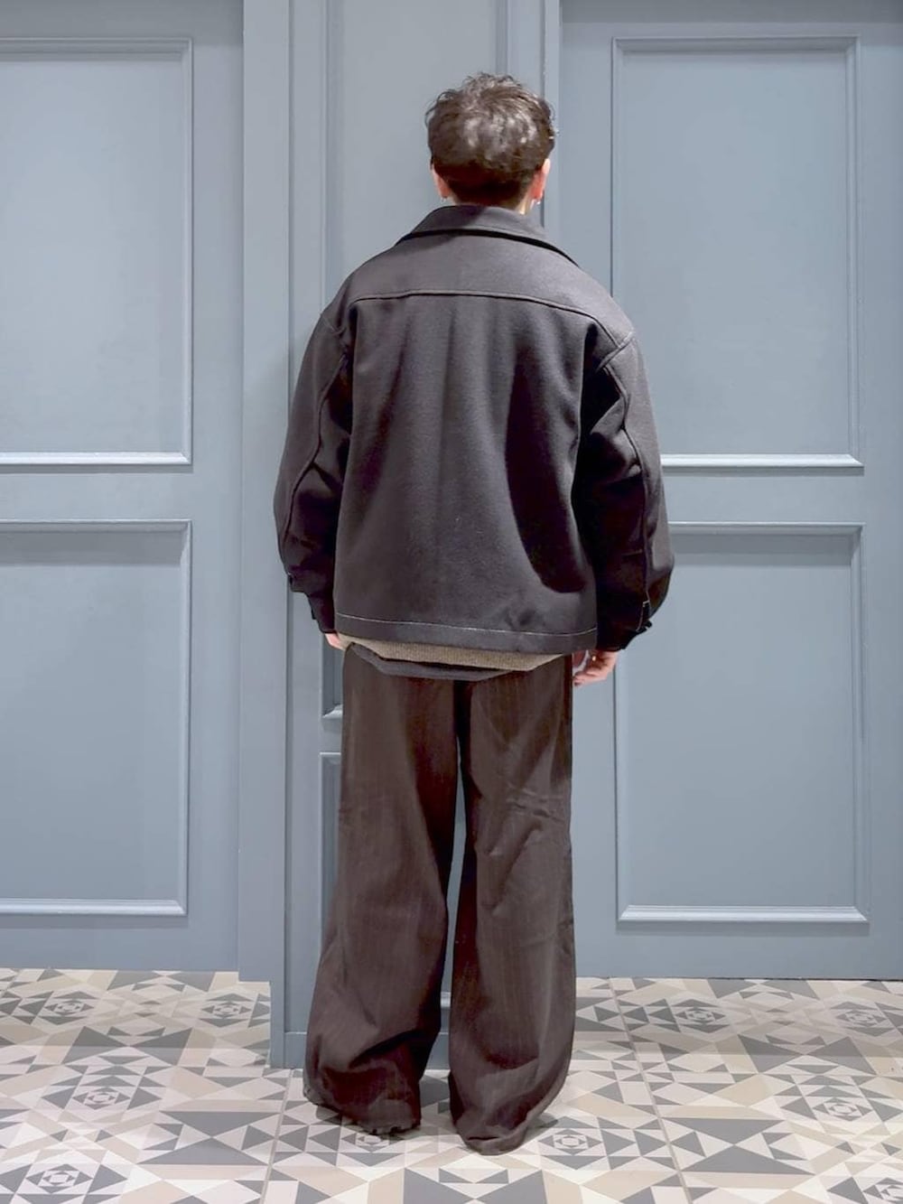 ブラウン系のスラックス、ブラック系のブルゾン、ブラック系のシャツ/ブラウスを着用したメンズの冬コーディネートの3枚目の写真