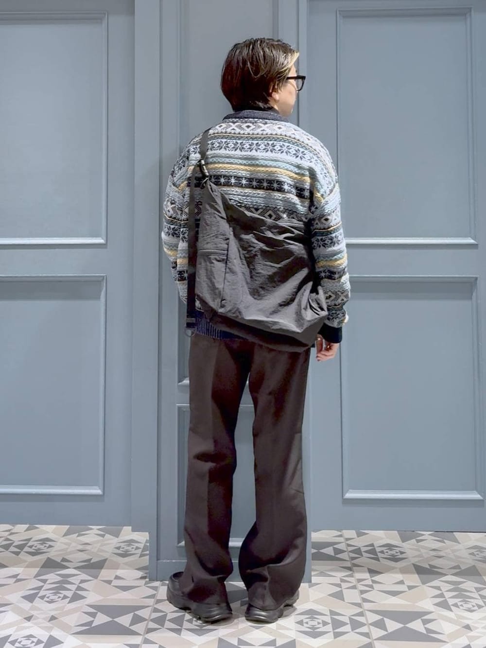 ブラウン系のスラックス、ブラック系のショルダーバッグ、ブラック系のローファーを着用したメンズの冬コーディネートの3枚目の写真