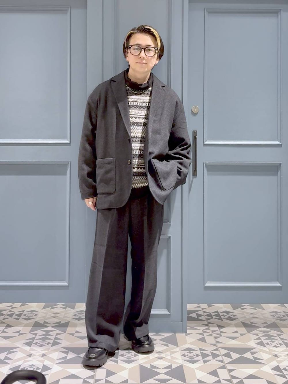 グレー系のニット/セーター、ブラック系のドレスシューズ、グレー系のテーラードジャケットを着用したメンズの秋コーディネートの4枚目の写真