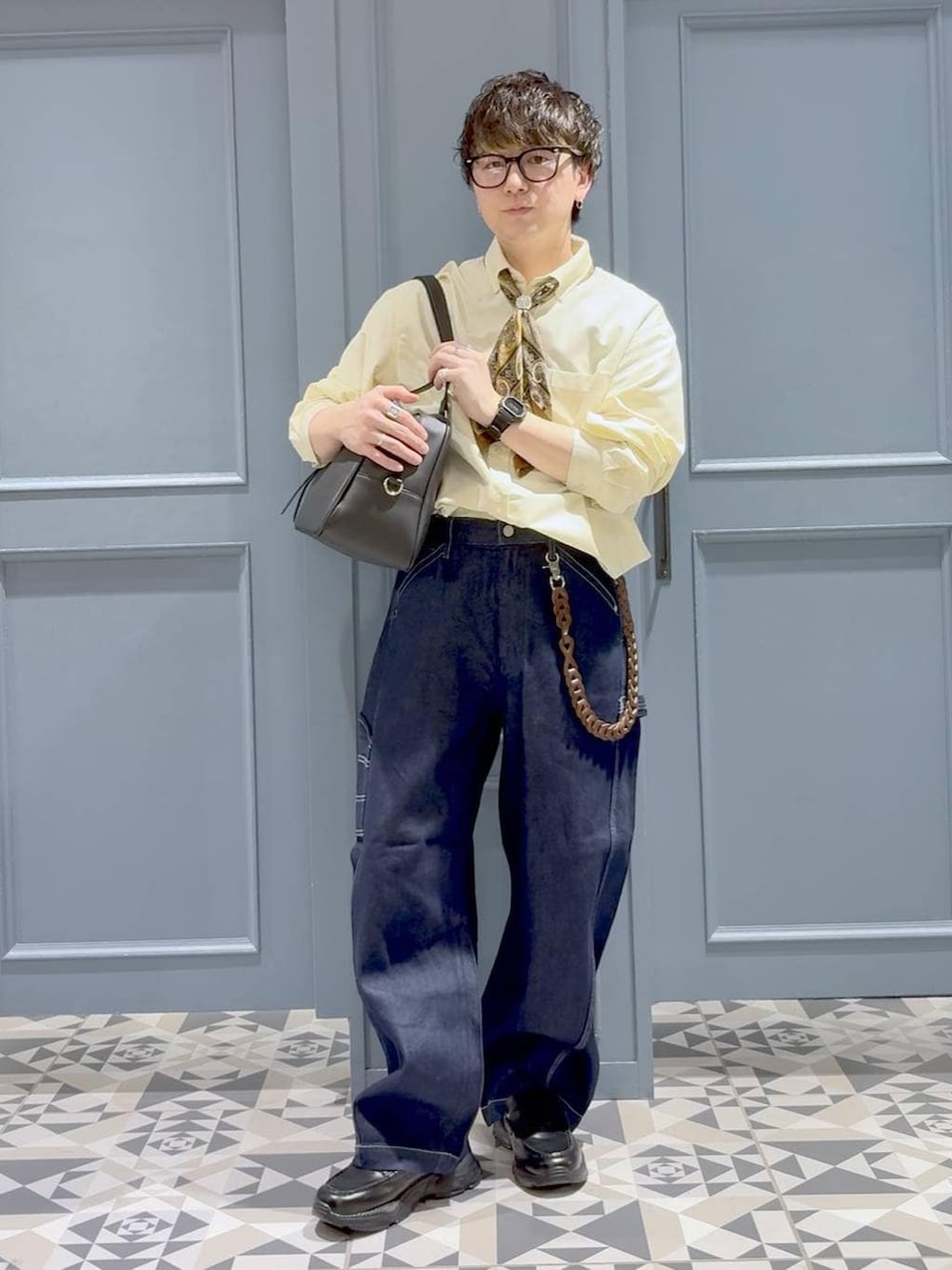 ブラック系のローファー、イエロー系のシャツ/ブラウス、ブルー系のデニムパンツを着用したメンズの春コーディネートの4枚目の写真