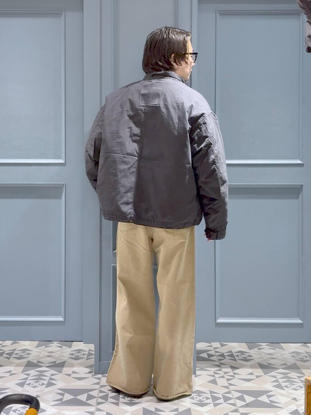 ベージュ系のデニムパンツ、グリーン系のモッズコート、グレー系のポロシャツを着用したメンズの冬コーディネートの3枚目の写真