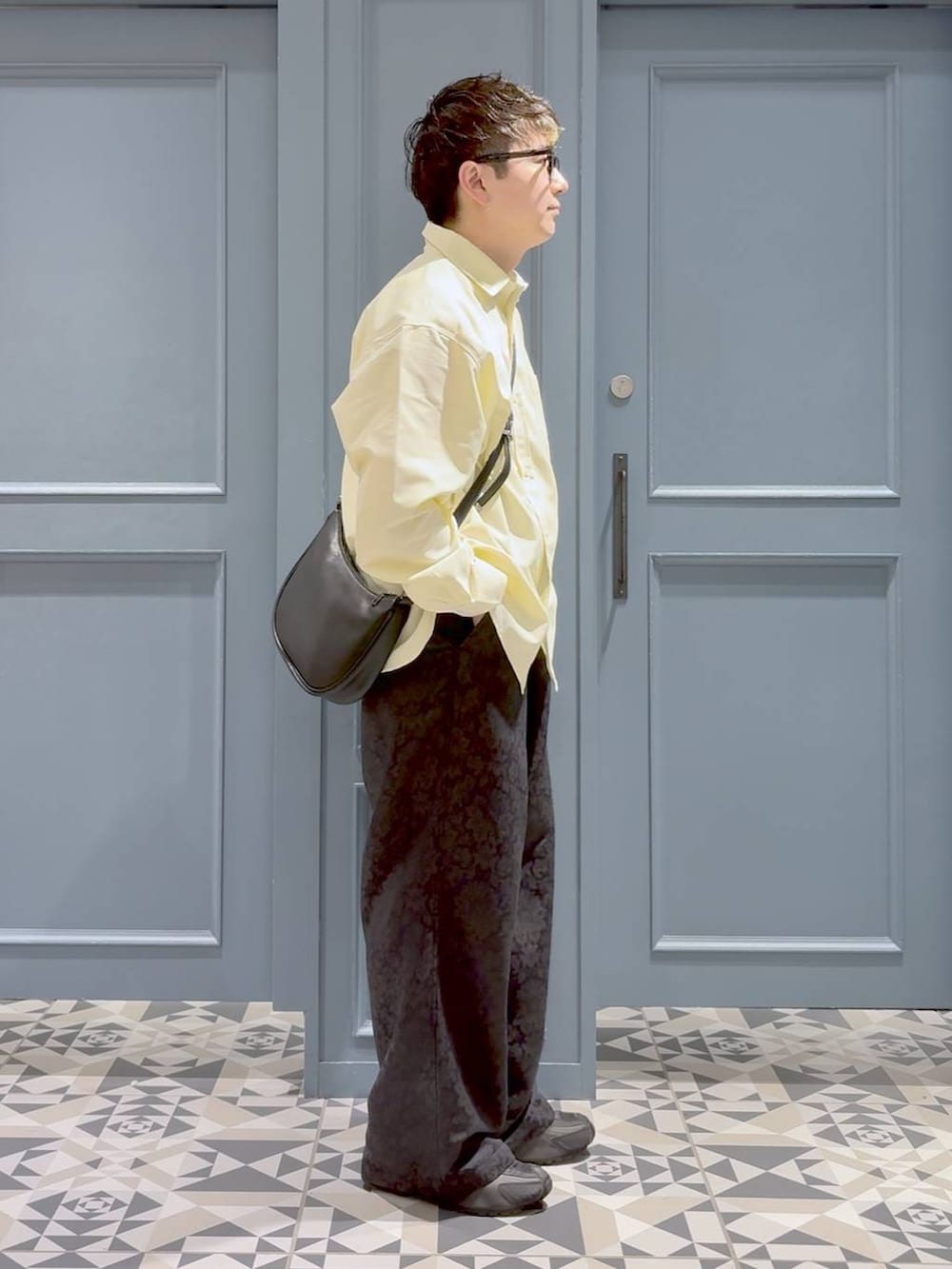 ブラック系のショルダーバッグ、イエロー系のシャツ/ブラウス、その他のスラックスを着用したメンズの冬コーディネートの2枚目の写真