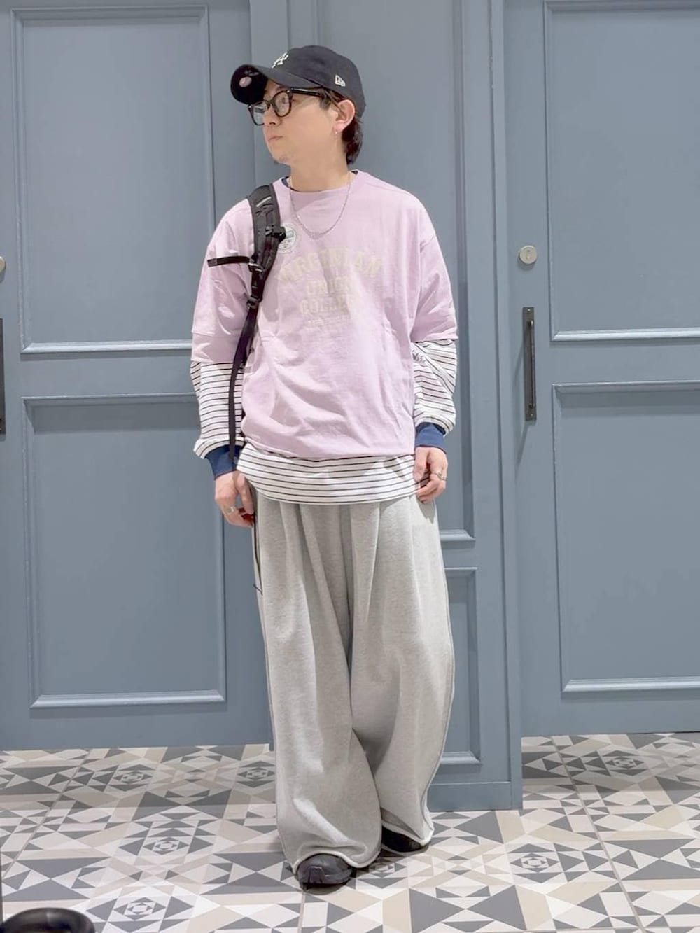 ブラック系のスニーカー、パープル系のTシャツ/カットソー、ホワイト系のTシャツ/カットソーを着用したメンズの春コーディネートの4枚目の写真