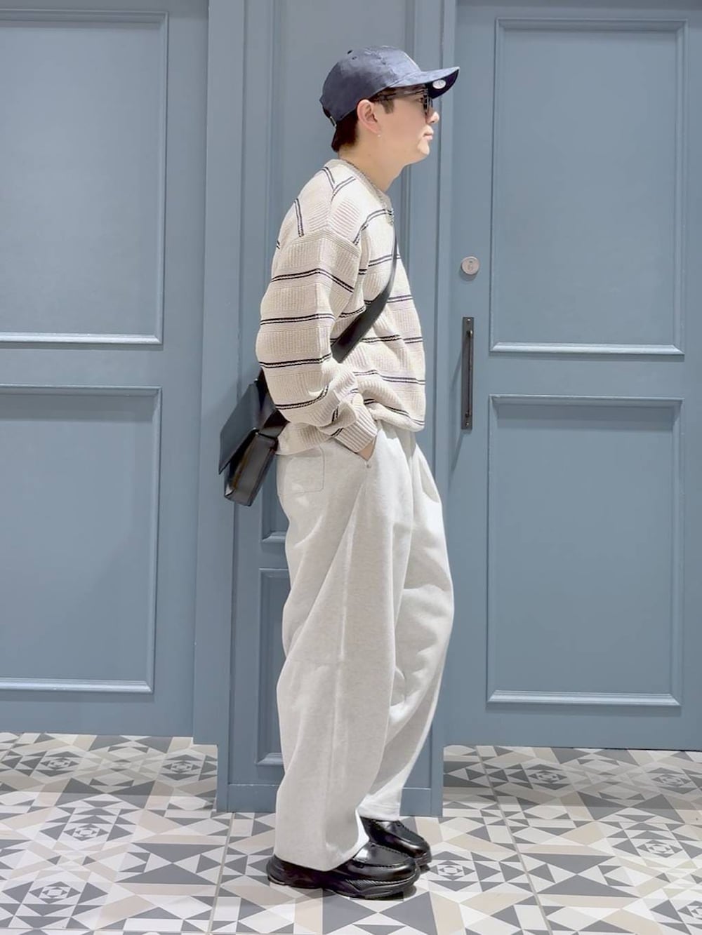 ブラック系のローファー、ブラック系のショルダーバッグ、グレー系のスウェットパンツを着用したメンズの冬コーディネートの2枚目の写真