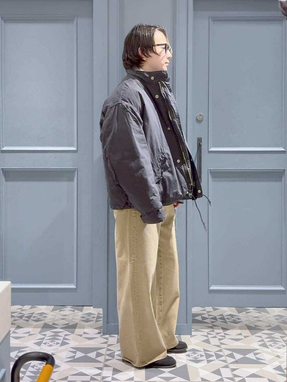 ベージュ系のデニムパンツ、グリーン系のモッズコート、グレー系のポロシャツを着用したメンズの冬コーディネートの2枚目の写真