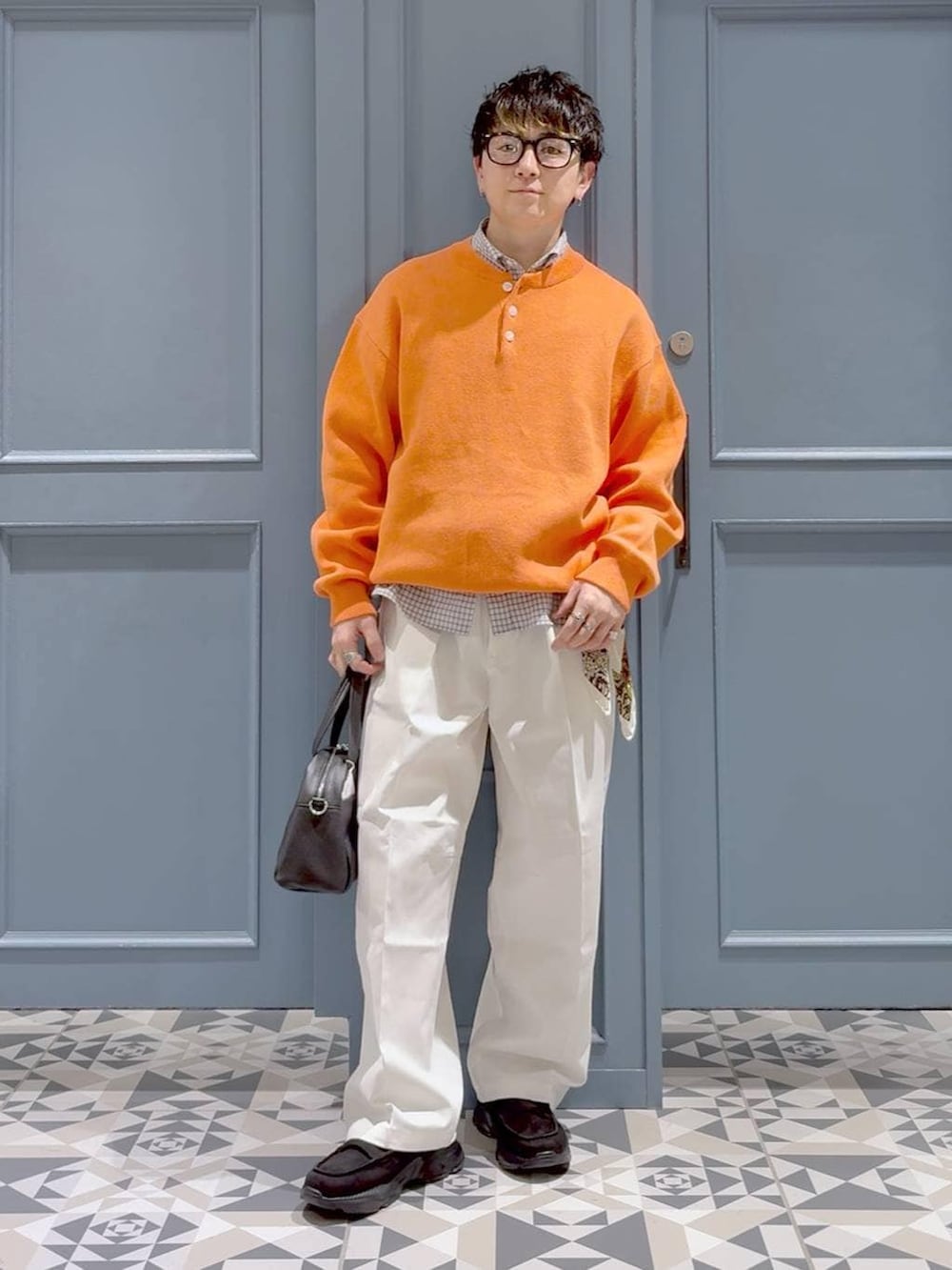 ブラック系のローファー、オレンジ系のニット/セーター、ホワイト系のシャツ/ブラウスを着用したメンズの冬コーディネートの4枚目の写真