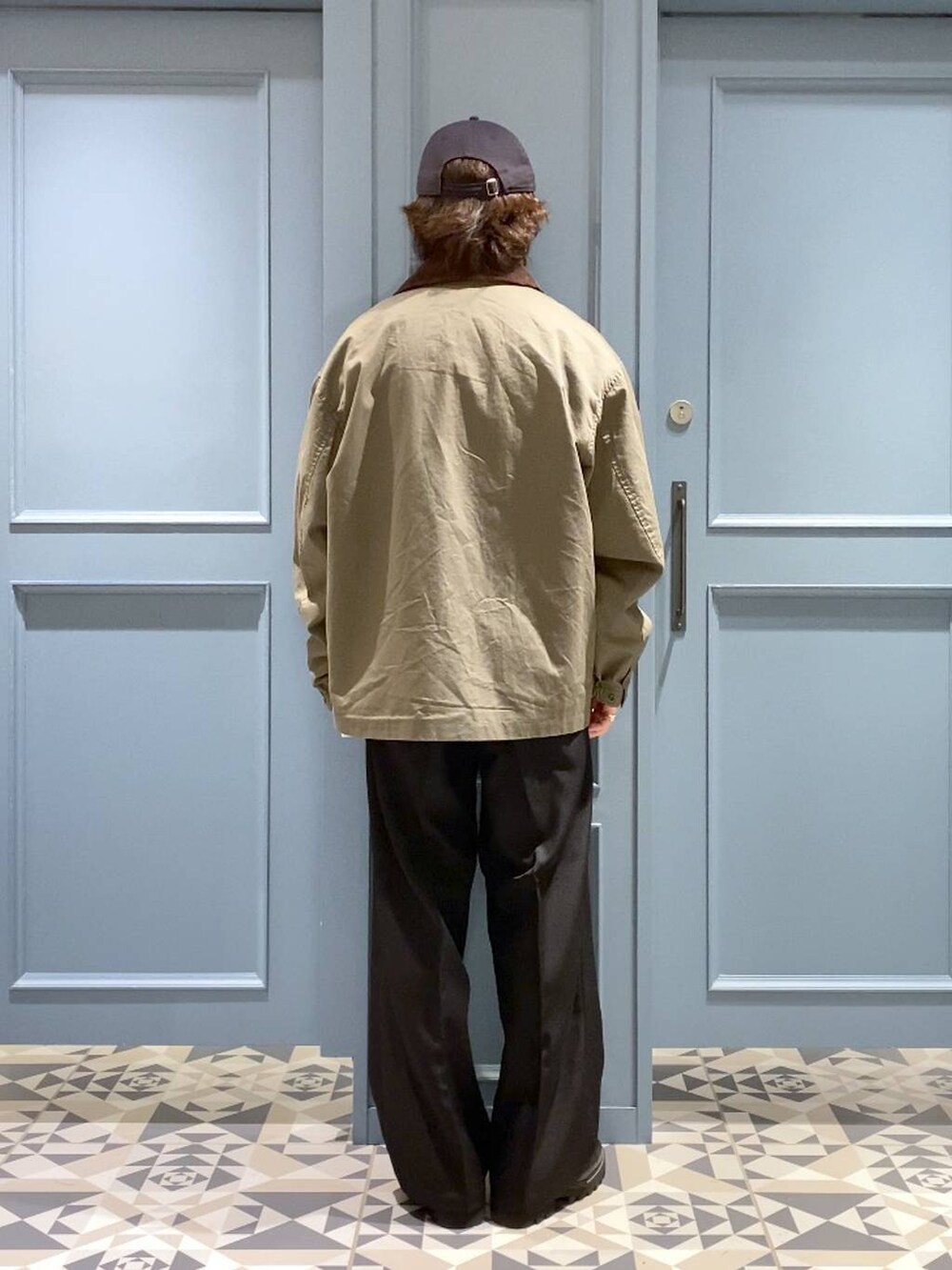 ブラック系のスラックス、グリーン系のブルゾン、ブラック系のドレスシューズを着用したメンズの秋コーディネートの3枚目の写真