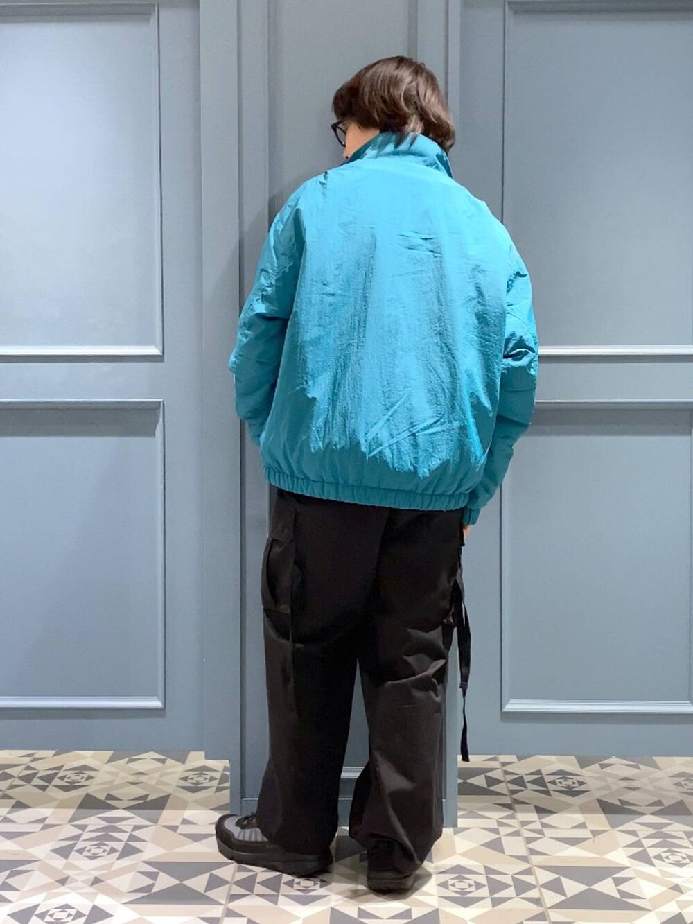 ブラック系のカーゴパンツ、ブラック系のスニーカー、ブラック系のニット/セーターを着用したメンズの冬コーディネートの3枚目の写真